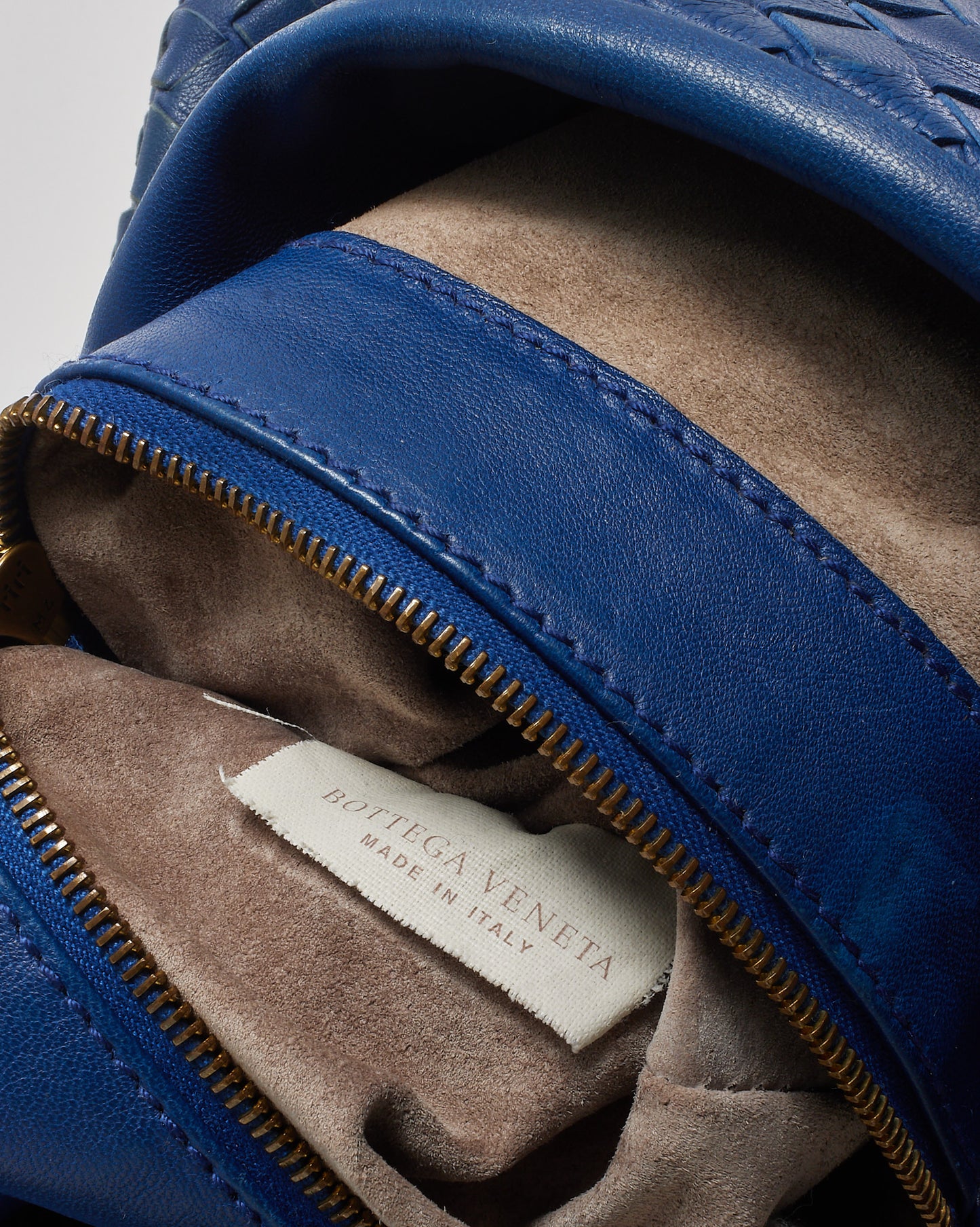 Blue leather shoe with a visible 'Bottega Veneta' label on a gray background
