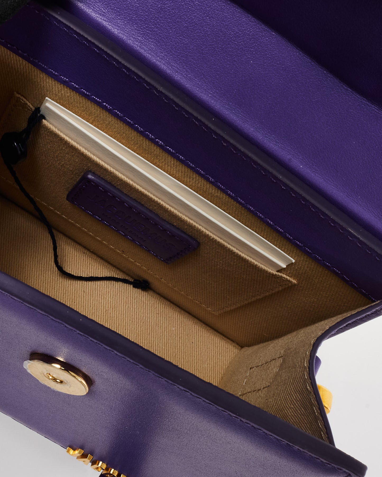 Pre-owned Jacquemus Le Chiquito Noeud mini handbag in vibrant violet leather, featuring a structured trapezoidal silhouette, circular top handles, and gold-tone logo detailing, inside view