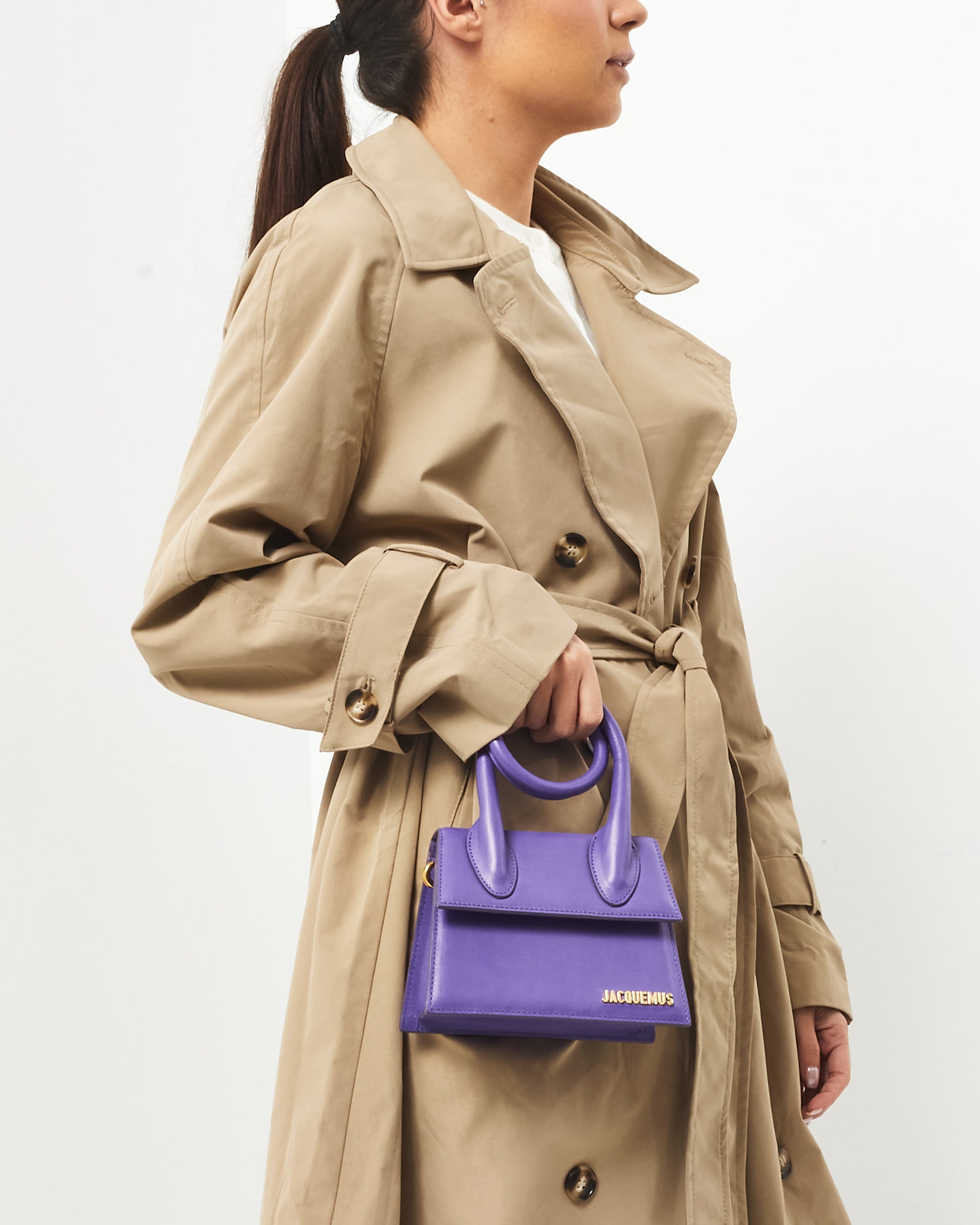 Jacquemus Pre-Owned Le Chiquito Noeud mini handbag in vibrant violet leather, featuring a structured trapezoidal silhouette, circular top handles, and gold-tone logo detailing  on body view